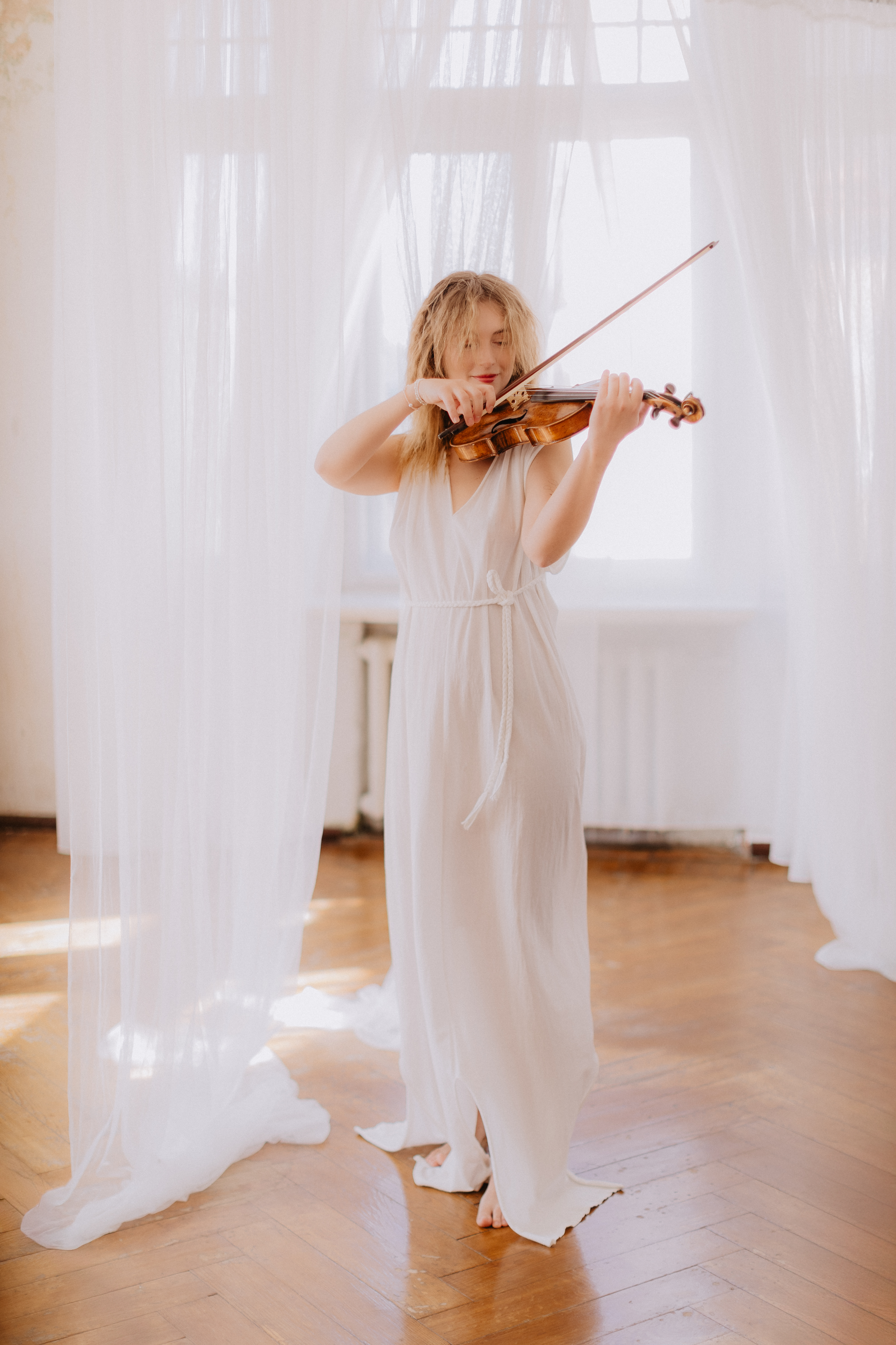 Vijolniece baltā kleitā atskaņo kāzu mūziku